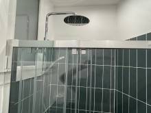 Colonne de douche à tête ronde dans une douche moderne (75015)