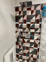 Robinetterie encastrée et carrelage géométrique et coloré dans la douche (75015)